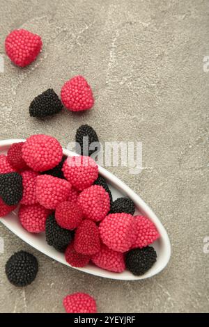 Bonbons à la framboise et à la mûre sur fond gris. Banque D'Images