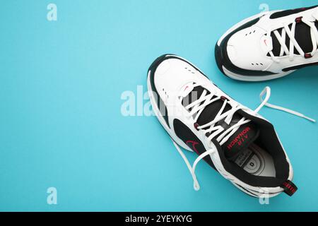 Mykolaiv, UKRAINE - juillet 2024. NIKE AIR MONARCH. Chaussures de sport de femme sur fond bleu. Banque D'Images