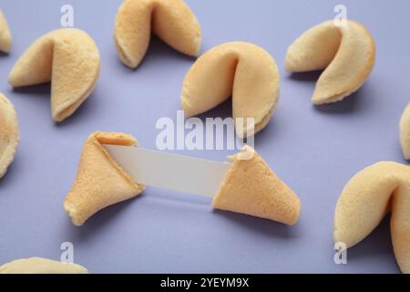 Savoureux biscuits de fortune et papier avec prédiction sur fond violet. Banque D'Images