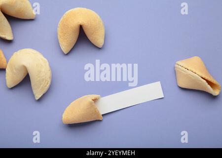 Savoureux biscuits de fortune et papier avec prédiction sur fond violet. Banque D'Images