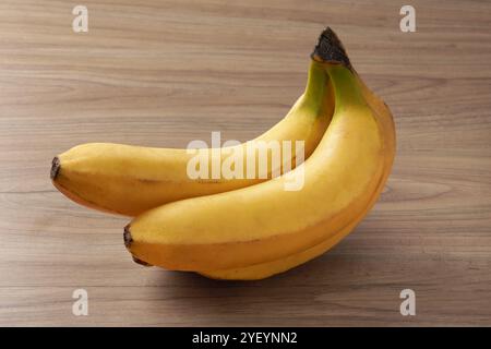 Un tas de belles bananes fraîches sur une table en bois Banque D'Images