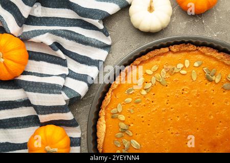 Délicieuse tarte à la citrouille avec des mini citrouilles sur fond de béton gris. Jour de Thanksgiving Banque D'Images