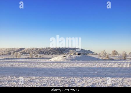 Passage tombe de l'âge de pierre sur une colline à un champ enneigé dans un paysage hivernal froid à la campagne, Karleby, Falkoeping, Suède, Europe Banque D'Images