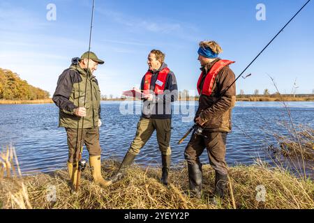 Brieskow Finkenheerd, Allemagne. 02 novembre 2024. Andreas Koppetzki (de gauche à droite), pêcheur à la ligne et directeur général de Landesanglerverband Brandenburg e.V. s'entretient avec Thilo Pagel de l'Institut des pêches intérieures Potsdam-Sacrow et Jan Kryszolik de l'Institut des pêches intérieures d'Olsztyn, Pologne, sur l'Oder. Pour la deuxième fois cette année, les pêcheurs de l'Oder sur le cours d'eau principal de la rivière sont invités à «pêche pour la science». L'objectif est d'observer l'évolution des stocks halieutiques. Crédit : Frank Hammerschmidt/dpa/Alamy Live News Banque D'Images