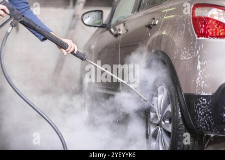 Lavage de voiture manuel avec eau sous pression dans le lavage de voiture extérieur Banque D'Images