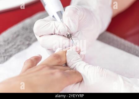 Processus de manucure professionnel, nettoyage des ongles avec une fraise à manucure, au salon beuticien Banque D'Images