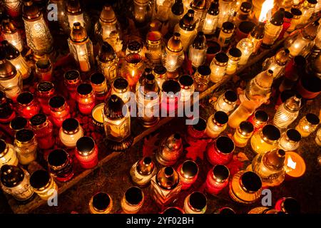 Cliché de nuit des flammes des bougies de cimetière en verre debout sur les pierres tombales. Le tir a été pris pendant la Toussaint, le 1 novembre. Banque D'Images