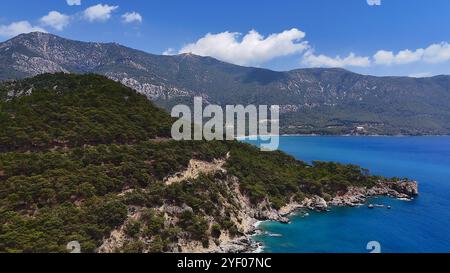 Côte montagneuse avec mer bleue et collines boisées Banque D'Images