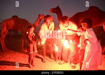 Ajmer, Inde. 02 novembre 2024. Les éleveurs de chameaux allument des pétards alors qu'ils célèbrent le festival Diwali à Pushkar. Diwali, également connu sous le nom de Festival des lumières, est l'un des festivals hindous les plus célébrés, symbolisant la victoire de la lumière sur les ténèbres et du bien sur le mal. (Photo de Shaukat Ahmed/Pacific Press) crédit : Pacific Press Media production Corp./Alamy Live News Banque D'Images