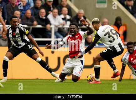 Bukayo Saka d'Arsenal (au centre) est attaqué par Joe Willock de Newcastle United (à gauche) lors du premier League match à St James' Park, Newcastle. Date de la photo : samedi 2 novembre 2024. Banque D'Images