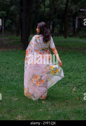 Une dame portant un saree fleuri coloré Banque D'Images