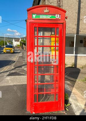 Church Village, Pontypridd, pays de Galles, Royaume-Uni - 16 août 2024 : défibrillateur de DAE destiné à aider les victimes d'une crise cardiaque rangé dans une cabine téléphonique publique convertie Banque D'Images