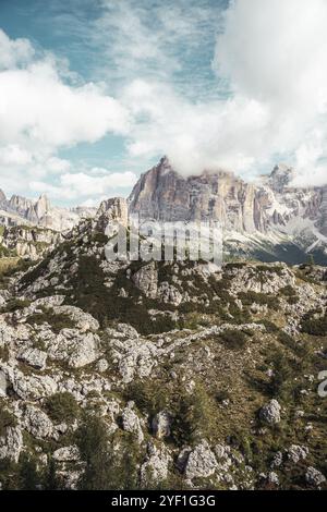 Une montagne majestueuse, entièrement recouverte de divers arbres et de grands rochers, se dresse bien en évidence contre un ciel nuageux qui remplit le fond Banque D'Images