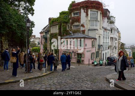 Touristes prenant des photos du célèbre restaurant 'la Maison rose' à Montmartre dans le 18ème arrondissement de Paris par un jour nuageux d'automne Banque D'Images