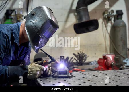 Métallurgiste opérant des machines industrielles dans un atelier de tissu métallurgique Banque D'Images