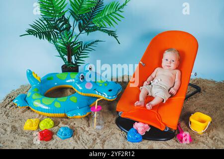 Un bébé est allongé sur un fauteuil inclinable pour bébés. Loisirs pour enfants. Banque D'Images