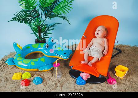 Un bébé est allongé sur un fauteuil inclinable pour bébés. Loisirs pour enfants. Banque D'Images