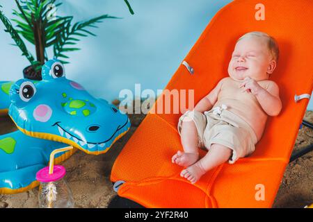 Un bébé est allongé sur un fauteuil inclinable pour bébés. Loisirs pour enfants. Banque D'Images