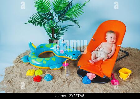 Un bébé est allongé sur un fauteuil inclinable pour bébés. Loisirs pour enfants. Banque D'Images