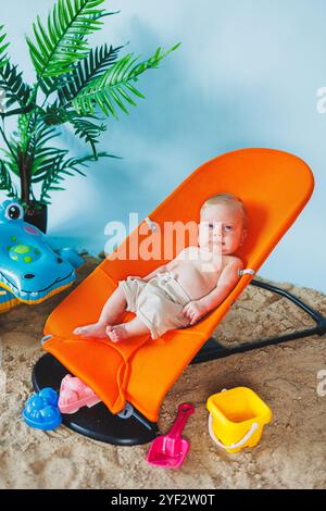 Un bébé est allongé sur un fauteuil inclinable pour bébés. Loisirs pour enfants. Banque D'Images