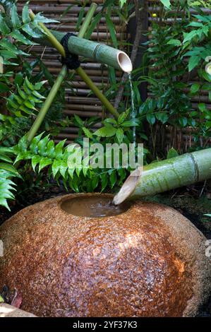 Un générateur de bruit shishi-odoshi thumper fait partie de l'eau dans un jardin japonais à l'origine destiné à effrayer les animaux de détruire les cultures. Banque D'Images