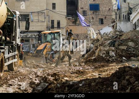 Tulkarm, Palestine. 02 novembre 2024. Des garçons palestiniens se tiennent près des travailleurs de l'ONU menant des travaux de réhabilitation à proximité du siège endommagé de l'UNRWA de l'agence des Nations Unies pour les réfugiés palestiniens dans le camp de réfugiés de Nur Shams à l'est de Tulkarem en Cisjordanie occupée, après que les forces israéliennes ont démoli la plupart du bâtiment lors de leur dernier raid dans le camp. Crédit : SOPA images Limited/Alamy Live News Banque D'Images