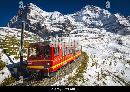 Chemin de fer de montagne avec train touristique rouge à crémaillère moderne sur la pente enneigée. Chemin de fer suisse célèbre, Jungfraujoch, Kleine Scheidegg, Grindelwald, Bernes Banque D'Images