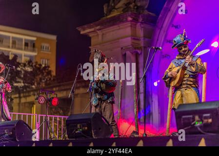 Logroño, la Rioja, Espagne. 02 novembre 2024. Groupe musical avec masques et costumes médiévaux se produisant sur scène illuminée, dans l'Auto de Fe Banque D'Images