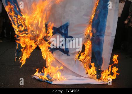 Téhéran, Iran. 3 novembre 2024. Un drapeau isréal brûle lors d'un rassemblement anti-américain marquant le 45e anniversaire de la prise de contrôle de l'ambassade américaine devant l'ancien bâtiment de l'ambassade à Téhéran. Le 4 novembre 1979, des étudiants iraniens se sont emparés de l'ambassade des États-Unis à Téhéran, retenant en otage plus de 50 diplomates et gardes américains pendant 444 jours. Et Israël suite à la récente frappe israélienne contre l'Iran. Crédit : ZUMA Press, Inc Crédit : ZUMA Press, Inc/Alamy Live News Banque D'Images