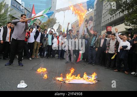 Téhéran, Iran. 3 novembre 2024. Des étudiants iraniens scandent des slogans alors que les Iraniens brûlent un drapeau isréal lors d'un rassemblement anti-américain marquant le 45e anniversaire de la prise de contrôle de l'ambassade américaine devant l'ancien bâtiment de l'ambassade à Téhéran. Le 4 novembre 1979, des étudiants iraniens se sont emparés de l'ambassade des États-Unis à Téhéran, retenant en otage plus de 50 diplomates et gardes américains pendant 444 jours. Crédit : ZUMA Press, Inc Crédit : ZUMA Press, Inc/Alamy Live News Banque D'Images