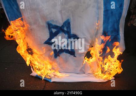 Téhéran, Iran. 3 novembre 2024. Un drapeau isréal brûle lors d'un rassemblement anti-américain marquant le 45e anniversaire de la prise de contrôle de l'ambassade américaine devant l'ancien bâtiment de l'ambassade à Téhéran. Le 4 novembre 1979, des étudiants iraniens se sont emparés de l'ambassade des États-Unis à Téhéran, retenant en otage plus de 50 diplomates et gardes américains pendant 444 jours. Et Israël suite à la récente frappe israélienne contre l'Iran. Crédit : ZUMA Press, Inc Crédit : ZUMA Press, Inc/Alamy Live News Banque D'Images