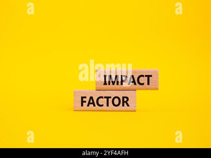 Symbole de facteur d'impact. Blocs en bois avec mots facteur d'impact. Beau fond jaune. Concept d'activité et de facteur d'impact. Copier l'espace. Banque D'Images