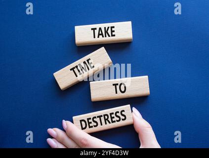 Symbole prendre le temps d'habiller. Les blocs de bois avec des mots prennent du temps à Destress. Beau fond bleu profond. Main d'homme d'affaires. Et prenez du temps Banque D'Images