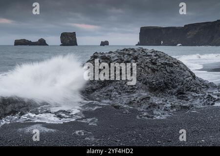 Vagues, surf, plage noire, plage de lave, basalte colonnaire, aiguilles de roche, longue exposition, Dyrholafjara, porte de roche Dyrholaey ou Dyrholaey, côte sud, glace Banque D'Images