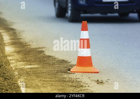 Avertissement cône de route de circulation sur la route asphaltée de ville pendant la restauration de la route, réparation de route, travaux de chaussée asphaltée sur l'autoroute automobile. Ne pas reconnaître Banque D'Images