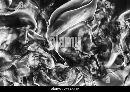 Panache abstrait de fumée noire naturelle et flamme blanche énorme de feu fort, flou de mouvement du feu, flammes à haute température. Noir et blanc capricieux Banque D'Images