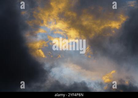 Magnifiques éclairs dorés et moelleux illuminés par des rayons en train de disparaître au coucher du soleil et des nuages sombres qui flottent dans le ciel pour changer le temps de la saison. Naturel Banque D'Images