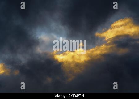 De superbes nuages d'orage moelleux illuminés par des rayons disparaissant au coucher du soleil et des nuages d'orage sombres flottant à travers le ciel pour changer le temps de la saison. S/O Banque D'Images