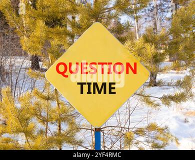 Symbole heure des questions. Mots conceptuels heure des questions sur le beau panneau routier jaune. Beau fond de forêt d'hiver. Heure des affaires et des questions Banque D'Images