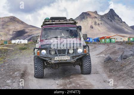 Véhicule utilitaire sport japonais Nissan Patrol conduisant sur une route de montagne rocheuse sur le paysage volcanique de fond. Voyage hors route, aventure dans Travel destin Banque D'Images