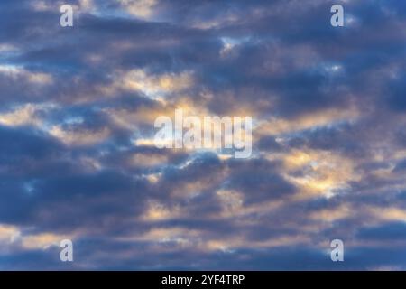 Beaux nuages dans le ciel bleu, illuminés par des rayons de soleil au coucher du soleil pour changer le temps estival. Flou de flou, flou de mouvement arrière multicolore de paysage nuageux Banque D'Images