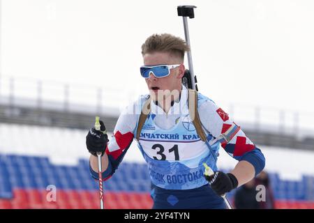 Sportif biathlète Zaytsev Aleksander Saint-Pétersbourg ski sur le stade de biathlon de distance après le tir à la carabine. Compétition régionale ouverte de biathlon jeunesse Banque D'Images