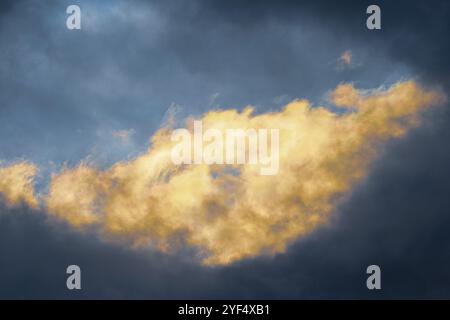 Vue incroyable météorologie naturelle arrière-plan, nuages d'orage moelleux illuminés par des rayons de disparition au coucher du soleil et des orages sombres flottant acr Banque D'Images