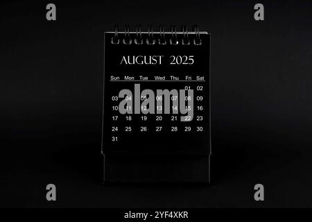 Calendrier noir pour août 2025. Calendrier de bureau sur un fond noir. Banque D'Images