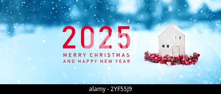 2025 élégante petite maison en céramique miniature de Noël sur fond de neige blanche. Décoration festive élégante. Joyeux Noël et joyeuses fêtes Banque D'Images