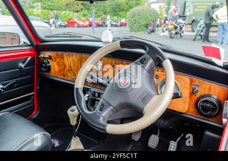 Carryduff County Down Northern Ireland 21 septembre 2024 - Mini Cooper tableau de bord en noyer avec volant en cuir et mini autocollant au milieu Banque D'Images