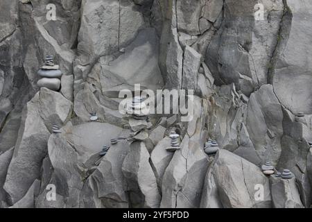 Une photographie de l’équilibrage des rochers sur la plage islandaise de Reynisfjara. Galets et pierres équilibrés sur sa falaise de basalte. Banque D'Images