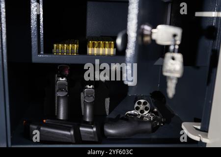 Armes à feu. Pistolets modernes, revolver et munitions dans un coffre-fort, photo rapprochée. Banque D'Images