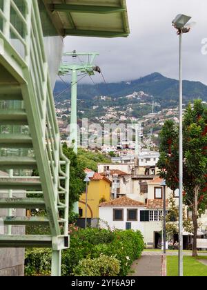 Une vue captivante comprend des gratte-ciel modernes combinés à des structures traditionnelles dispersées dans un paysage urbain vallonné, sous un ciel nuageux, montrant ur Banque D'Images