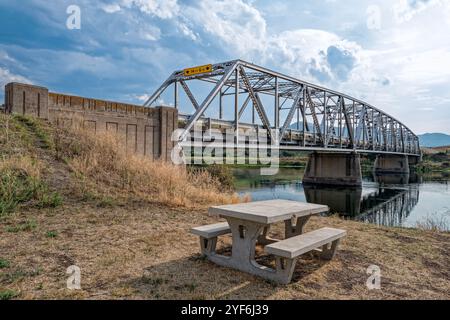 Une table de pique-nique en béton sous le pont sur le fleuve Missouri près de Wolf Creek dans le Montana, États-Unis Banque D'Images